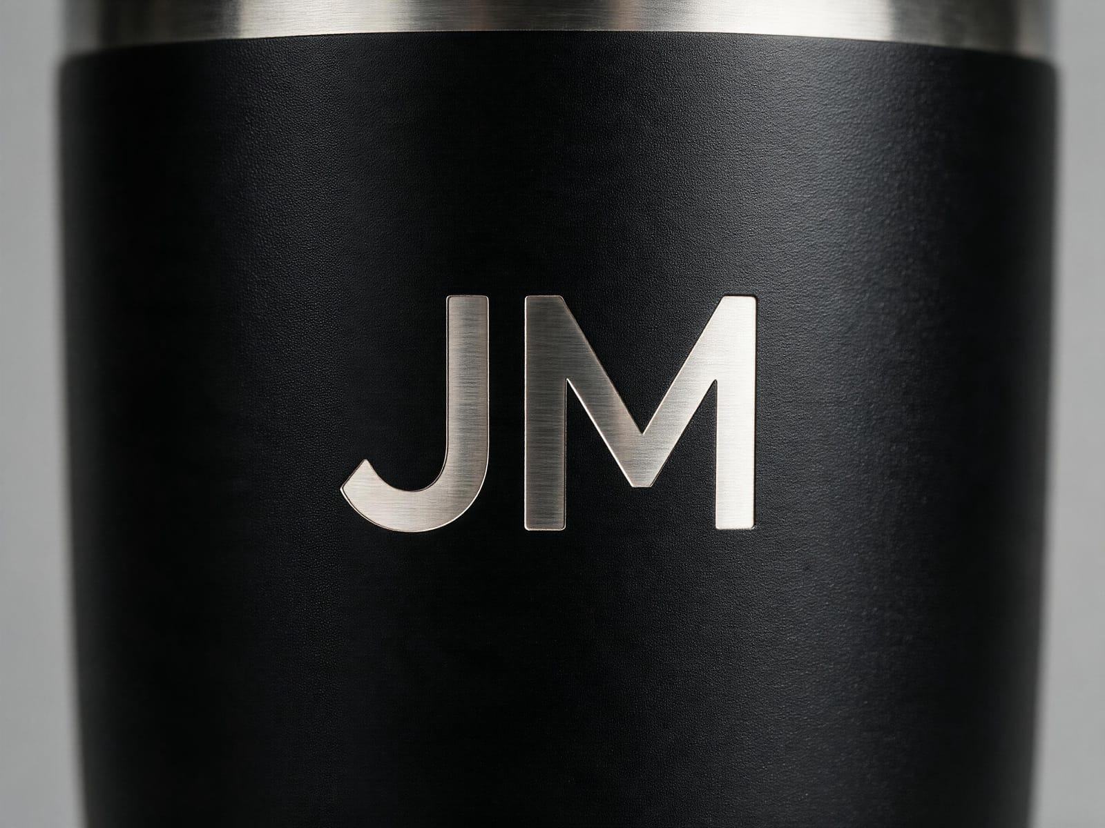 Macro of a matte black tumbler with a silver engraved name